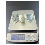 A serene moss agate collection featuring two hand-carved leaf-shaped pieces and a polished sphere with a druzy center resting on a lotus stand.