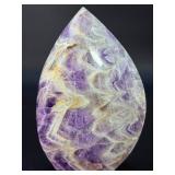 A Chevron Amethyst Freeform is a beautiful, naturally shaped crystal that features striking V-shaped banding of deep purple amethyst and milky white quartz. Also known as Dream Amethyst,