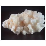 Peach Stilbite is a delicate and captivating crystal known for its soft, peachy-pink color and intricate, fan-like formations. Often found in clusters, the crystal’s radiating, layered structures ca