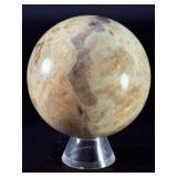 Moonstone Sphere with Blue Flashes is a captivating crystal sphere known for its soft, luminous glow and stunning blue flashes that shimmer as the light moves across its surface.