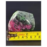 Ruby Zoisite is a striking natural stone that beautifully blends vibrant ruby inclusions with earthy green zoisite, often accented by dark hornblende veins.