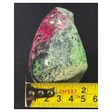 Ruby Zoisite is a striking natural stone that beautifully blends vibrant ruby inclusions with earthy green zoisite, often accented by dark hornblende veins.