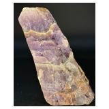 Raw Chevron Amethyst showcases the stone in its natural, unpolished form, highlighting bold V-shaped bands of deep purple amethyst and milky white quartz.