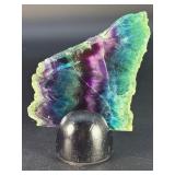 Rainbow Fluorite Slab is a stunning, polished slice that showcases fluorite’s signature bands of purple, green, blue, and soft teal hues.