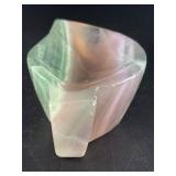 Fluorite Leaf Dish is a hand-carved crystal piece shaped like a delicate leaf bowl, showcasing the natural banding and vibrant colors of fluorite.