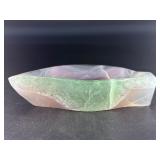 Fluorite Leaf Dish is a hand-carved crystal piece shaped like a delicate leaf bowl, showcasing the natural banding and vibrant colors of fluorite.