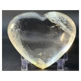 Natural Clear Quartz Puffy Heart with inclusions is a charming, hand-polished crystal carved into a soft, rounded heart shape.