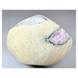 A natural amethyst geode filled with shimmering violet quartz crystals, accented by soft white calcite and encased in its original stone shell.