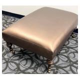 Copper/Brass Colored Covered Ottoman Footstool with Turned Wood Legs & Casters