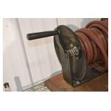 Hose Reel with Red Rubber Hose on a Metal Spool and Hand Crank