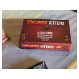Games including Cribbage Boards, Exploding Kittens Card Game, and AON Safety First Playing Cards