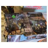 Radio Shack Fast Charger and a RGM-79SP GM Sniper II model kit, and a toy ATV with rider.