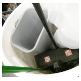 garbage barrel with roll of poly and broom