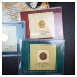 an assortment of 6 various gold plated coins: 3 IHP