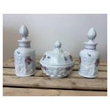 This is a vintage Westmoreland milk glass dresser set in the "Paneled Grape" pattern, hand-painted with a "Roses & Bows" design. The set includes two perfume bottles with stoppers, a covered powder bo