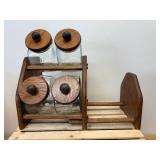 Vintage general store style canister set, The item is a set of four clear glass jars with solid wooden lids and a matching wooden storage rack
