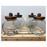 Vintage general store style canister set, The item is a set of four clear glass jars with solid wooden lids and a matching wooden storage rack
