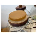 Vintage general store style canister set, The item is a set of four clear glass jars with solid wooden lids and a matching wooden storage rack