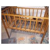 This appears to be a vintage wooden baby crib or bassinet,