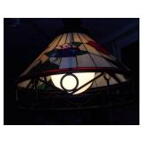 This is a Tiffany-style stained glass hanging pendant light fixture with a floral motif and a wrought iron frame