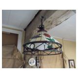 This is a Tiffany-style stained glass hanging pendant light fixture with a floral motif and a wrought iron frame
