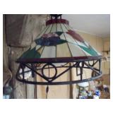 This is a Tiffany-style stained glass hanging pendant light fixture with a floral motif and a wrought iron frame