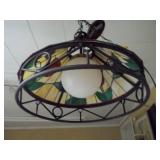 This is a Tiffany-style stained glass hanging pendant light fixture with a floral motif and a wrought iron frame