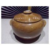 This is a vintage stoneware bean pot with a lid and handles.