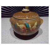 This is a vintage stoneware bean pot with a lid and handles.