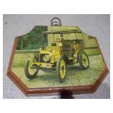 These are vintage wall plaques featuring art of antique cars