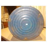 The can is a large, blue metal drum with a heavily worn paper label