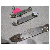 several "church key" style can and bottle openers, spoons, and other small metal objects.