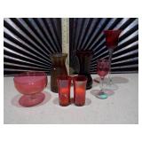 This collection features various pieces of cranberry glass stemware and vases