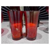 This collection features various pieces of cranberry glass stemware and vases