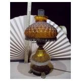 This is a vintage mid-century modern amber glass hurricane table lamp