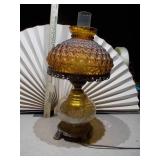 This is a vintage mid-century modern amber glass hurricane table lamp