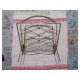 This is a mid-century modern atomic brass magazine rack