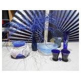 The image displays a collection of various cobalt blue glass items,