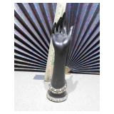 A dark, hand-shaped sculpture