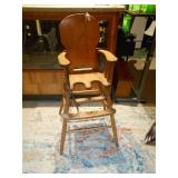 This is a vintage or antique wooden high chair,