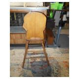 This is a vintage or antique wooden high chair,