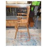 This is a vintage or antique wooden high chair,