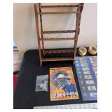 World Travel Collectibles Lot Including Iraqi Coins, Foreign Currency, Spoons, Figurines, and Wooden Display Rack