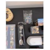 World Travel Collectibles Lot Including Iraqi Coins, Foreign Currency, Spoons, Figurines, and Wooden Display Rack