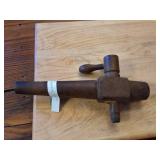 This is an antique wooden barrel spigot or tap. 