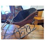 Vintage wicker and wrought iron decorative sleigh, often used as Christmas or holiday home decor