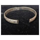 Sterling silver hinged bangle bracelet with a starburst and wave etched design.