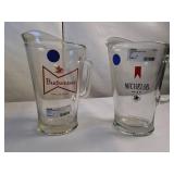 Vintage Budweiser and Michelob glass beer pitchers featuring classic breweriana branding.