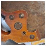 A collection of cutting tools, primarily circular saw blades for power saws and traditional hand saws.