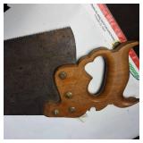 A collection of cutting tools, primarily circular saw blades for power saws and traditional hand saws.